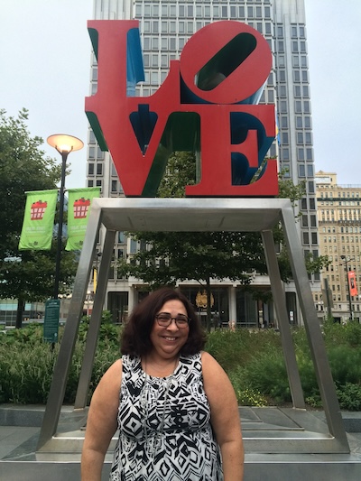 Haydee standing under the LOVE sculpture