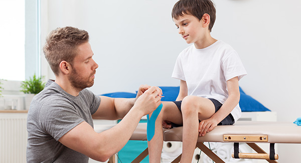 hombre vendando la rodilla de un niño