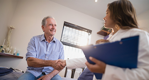 Female doctor and male patient shaking hands