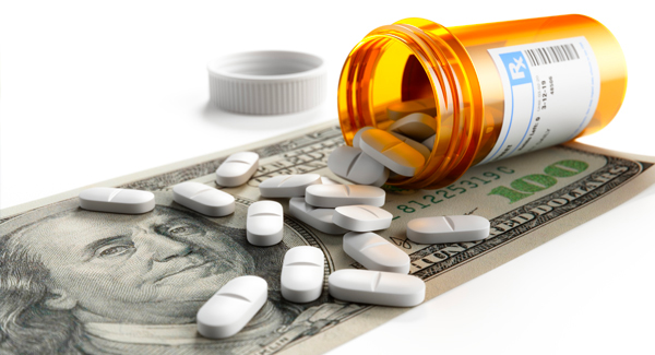 pills and pill bottle laying on a 100 dollar bill