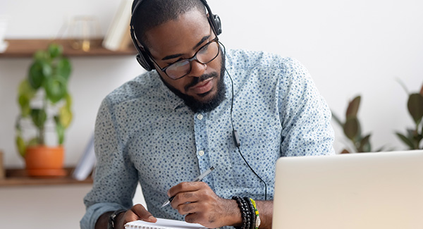 man with headphones looking at his laptop