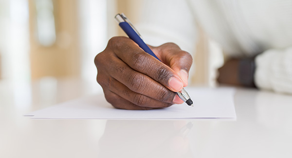 close up of person writing on paper